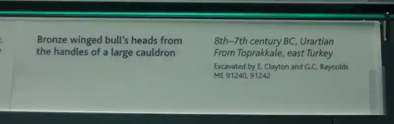 A winged bull head with wings from a large cauldron